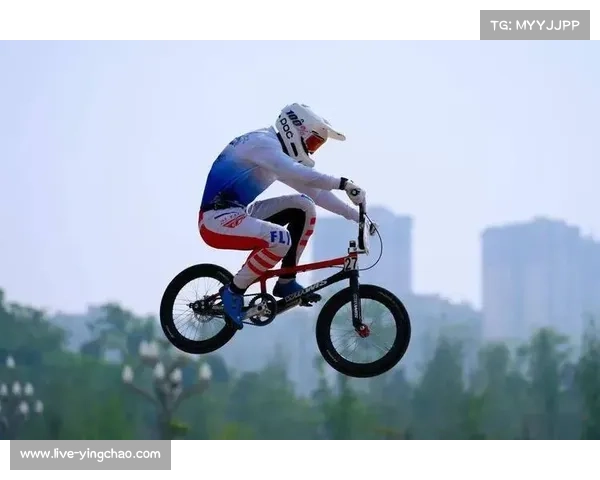 BMX泥地竞速赛现场，选手疾速俯冲飞跃障碍包，观众欢呼不断